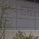Exterior view of Snohomish County Corrections building with large raised lettering on gray panels and some plants in the foreground.