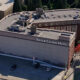 Aerial view of the Silver Cloud Hotel showing a large brick building with a sign reading 'Silver Cloud Hotel' and a mostly empty parking lot on the foreground.