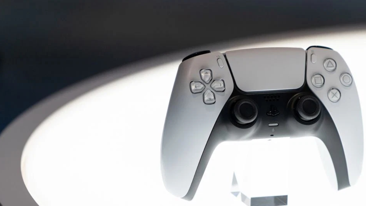 White PlayStation 5 DualSense wireless controller facing forward, with joysticks and buttons visible against a soft background.