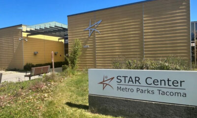 Exterior of STAR Center in Metro Parks Tacoma, beige building with a star logo and a large sign in the foreground reading 'STAR Center Metro Parks Tacoma'.