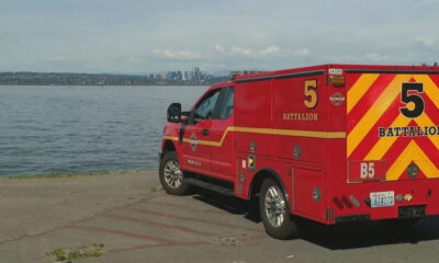 Red emergency rescue vehicle parked by a lake with the city skyline in the distance, labeled 5 Battalion on the side and back.