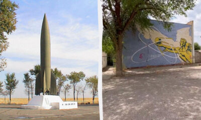 Left: tall green rocket monument in a plaza with trees and a white base; right: blue graffiti mural on a wall showing a yellow figure aiming a gun with white abstract lines.