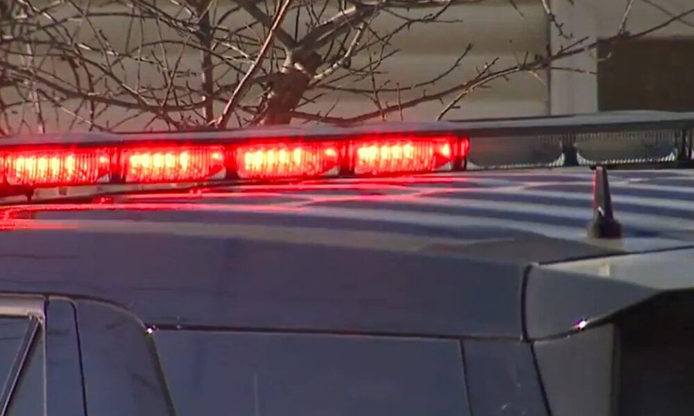 Police vehicle with red emergency lights flashing on its roof