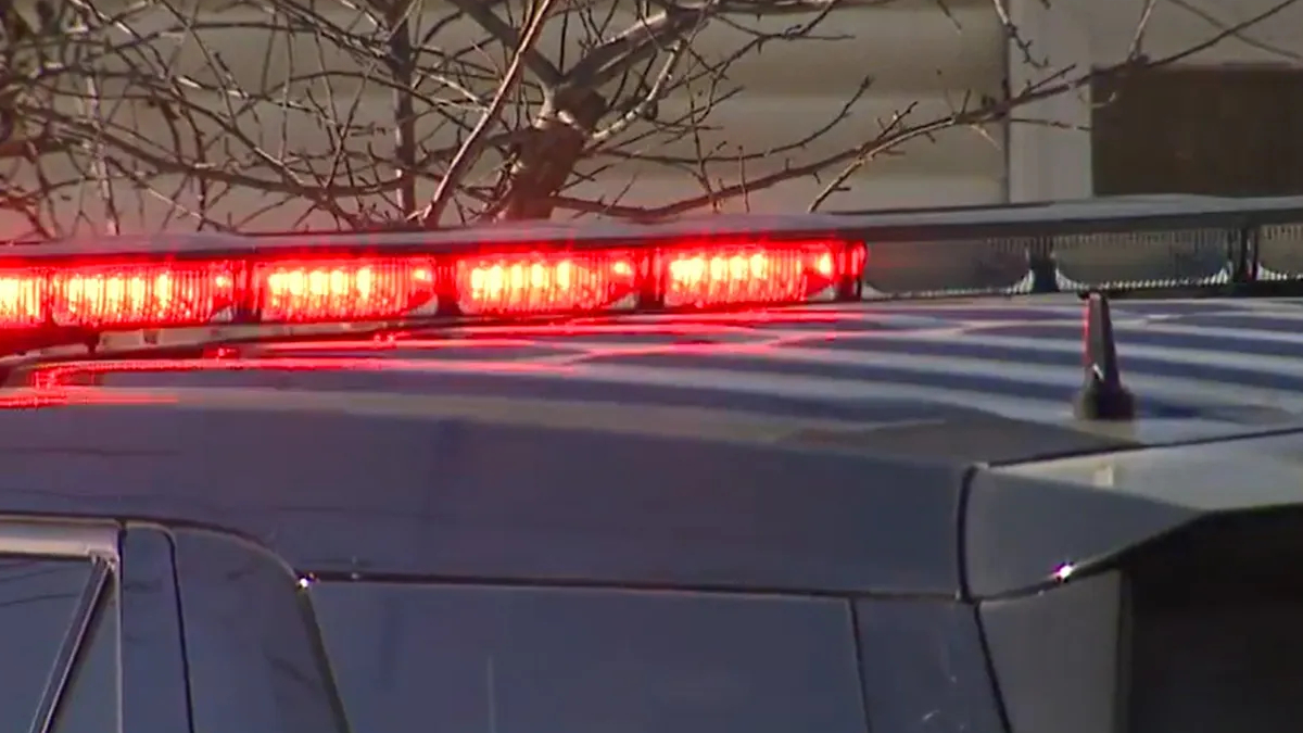 Police vehicle with red emergency lights flashing on its roof