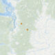 Map showing two orange location markers inland on a mountainous region of a coastal map.