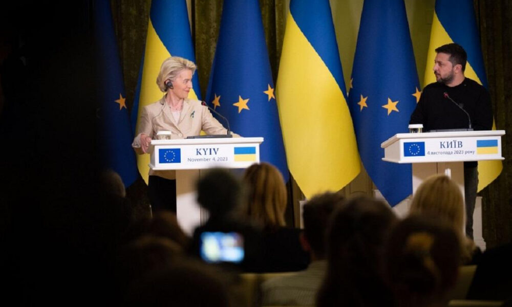 Two officials speak at separate podiums during a press conference with EU and Ukrainian flags behind them in Kyiv.
