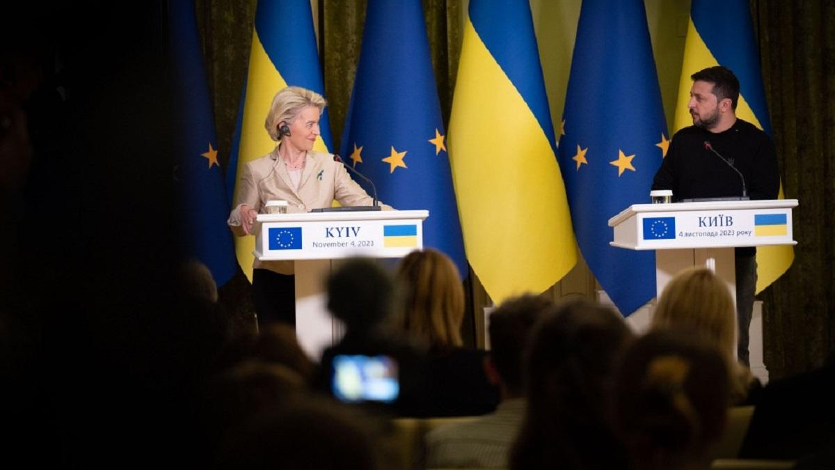 Two officials speak at separate podiums during a press conference with EU and Ukrainian flags behind them in Kyiv.