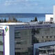 Modern glass-front hospital building with signage reading 'Mary Bridge Children's Hospital' and a distant waterfront.
