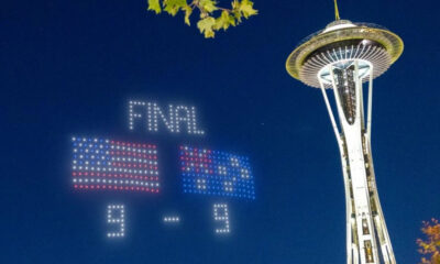 Night scene in Seattle with the Space Needle; a bright LED scoreboard shows FINAL 9-9 under a starry sky.