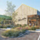 Rendering of a modern cafe with wood siding, large glass walls, and landscaped planters; people walk toward the entrance.