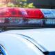 Red and blue police lights on top of a patrol car, flashing in daylight