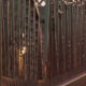 Long metal arch bridge with vertical suspender cables, illuminated streetlights along the deck at dusk.
