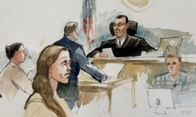 A courtroom sketch showing a judge at the bench, a defendant seated, and several people seated or standing nearby in a court setting.