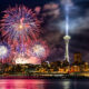 Fireworks over Seattle skyline at night with the Space Needle illuminated near the center.