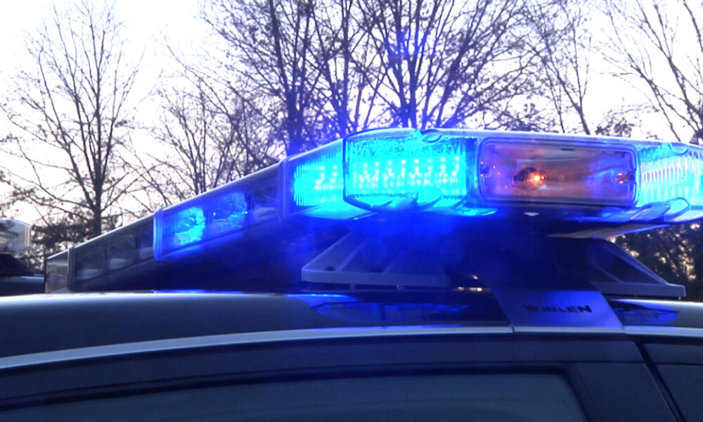 Police car with blue flashing lights on top at dusk