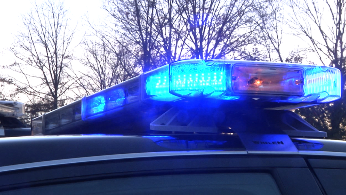 Police car with blue flashing lights on top at dusk