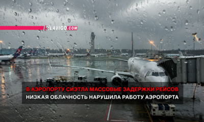 Дождливый аэропорт Сиэтла: самолёт у трапа на мокром перроне, поверх фото — новости о массовых задержках рейсов из‑за низкой облачности.