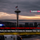 Seattle skyline at sunset featuring the Space Needle with flashing police lights in the foreground and a Russian news banner across the bottom.