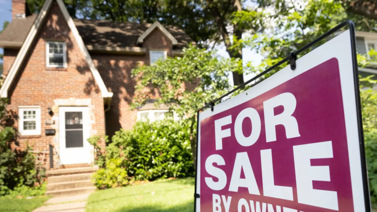 A large magenta 'FOR SALE' sign in the yard with a brick suburban house and greenery in the background.