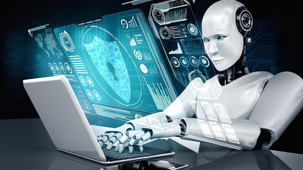 Humanoid robot typing on a laptop with glowing blue holographic security and data dashboards in front of it.