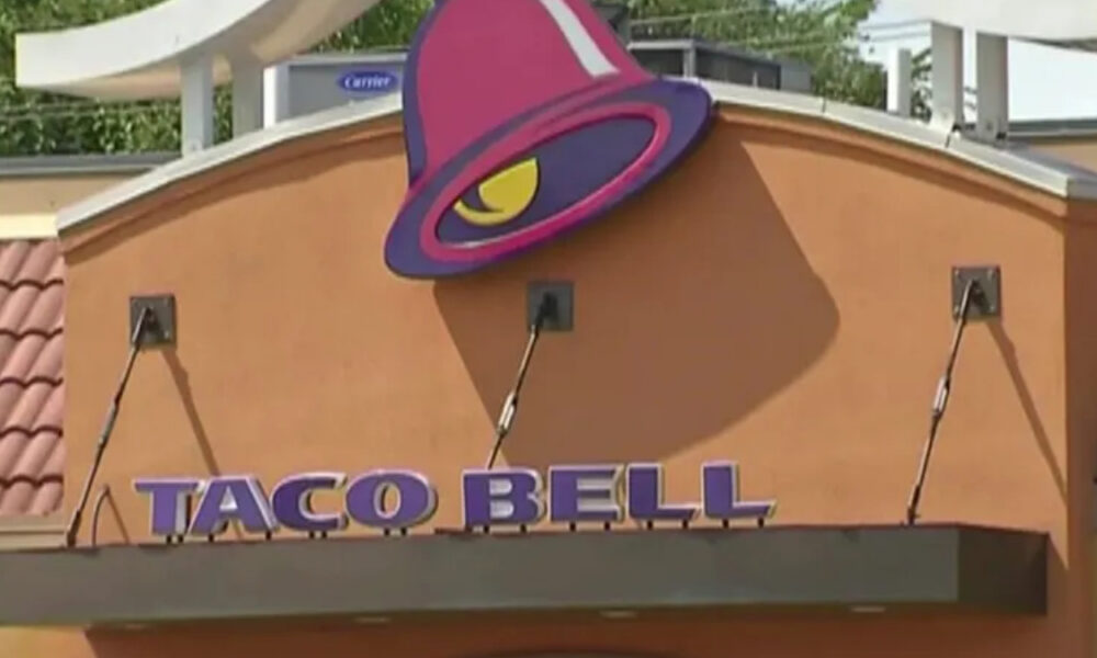 Taco Bell restaurant exterior with a purple bell-shaped logo on an orange facade.