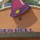 Taco Bell restaurant exterior with a purple bell-shaped logo on an orange facade.