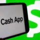 Phone screen showing the Cash App logo and text on a green background with a green dollar icon on the left.