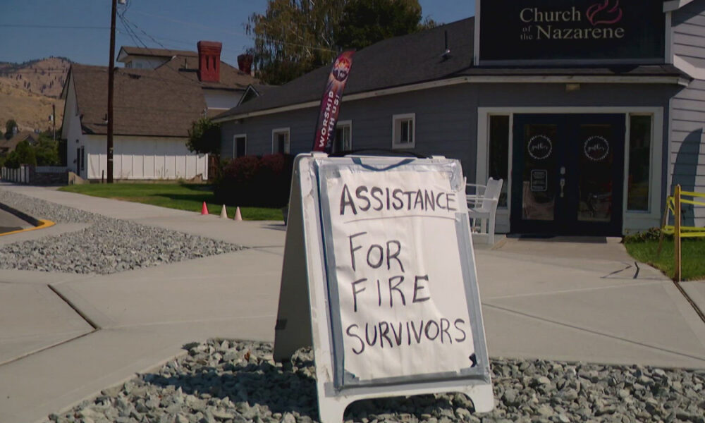 A-frame sign outside a church reads 'ASSISTANCE FOR FIRE SURVIVORS' offering help to fire victims.