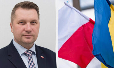 Portrait of a man in a suit beside Polish and Ukrainian flags.