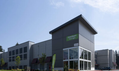 Exterior of an Extra Space Storage facility with gray metal panels and a large glass entrance.