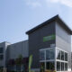 Exterior of an Extra Space Storage facility with gray metal panels and a large glass entrance.