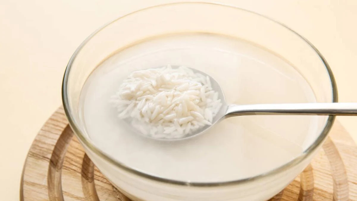 Bowl of white rice porridge (congee) with a metal spoon resting in the liquid.