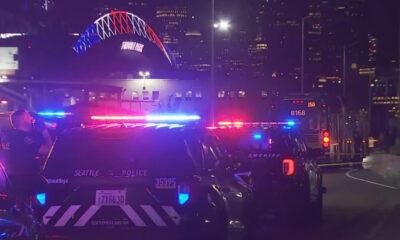 Seattle police cars with flashing red and blue lights at night in an urban area.
