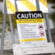 Caution sign near a lake warning that toxic algae may be present and the lake may be unsafe for people and pets.