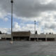 Hobby Lobby store in a strip mall with a mostly empty parking lot and a moving truck parked to the left under a cloudy sky