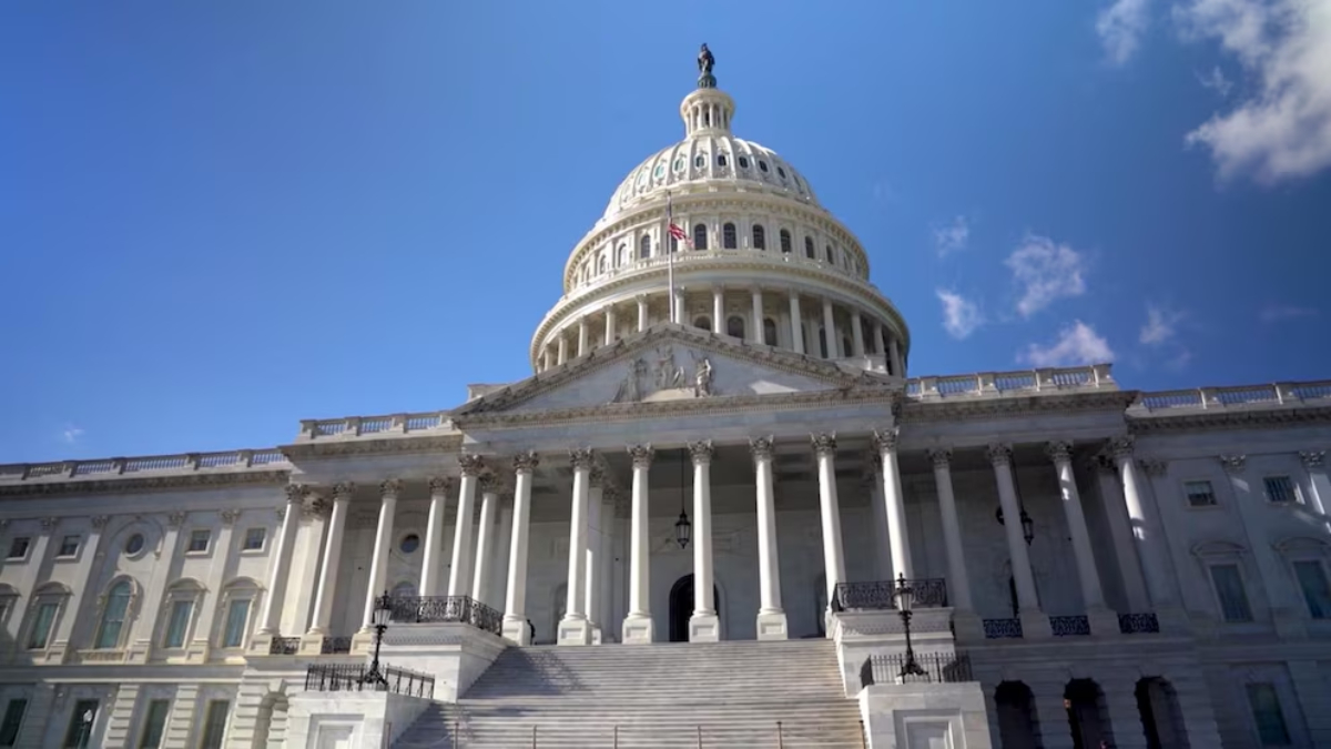 Front view of the U.S. Capitol with its dome, steps, and tall white columns against a blue sky.
