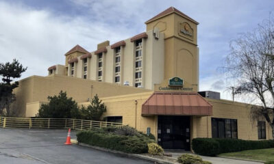 Beige hotel/conference center with a red awning over the entrance and a sign that reads 'Conference Center' at the front.