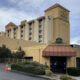 Beige hotel/conference center with a red awning over the entrance and a sign that reads 'Conference Center' at the front.