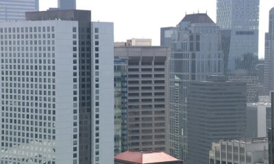 City skyline with tall modern office buildings and glass facades in a dense urban downtown area