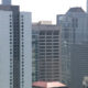 City skyline with tall modern office buildings and glass facades in a dense urban downtown area