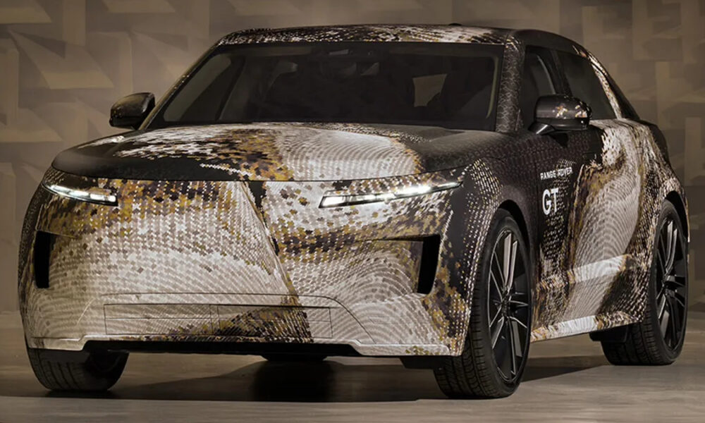 Front three-quarter view of a camouflaged Range Rover concept car with a brown/cream digital wrap in a studio setting.