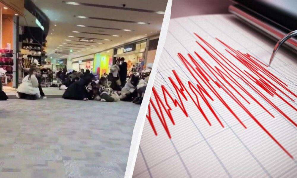 Crowded shopping mall floor with people crouching, next to a seismograph showing jagged red lines indicating shaking.