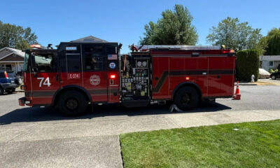 Red fire engine parked on a residential street with the number 74 on the door and equipment panels visible on the side.