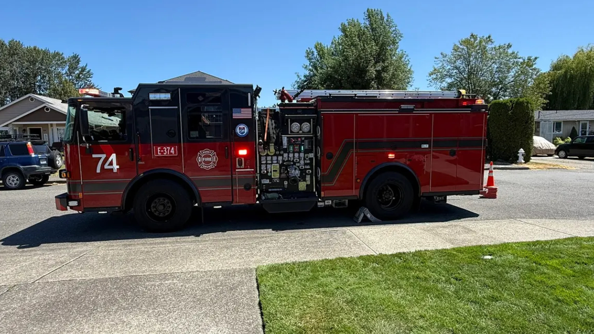 Red fire engine parked on a residential street with the number 74 on the door and equipment panels visible on the side.