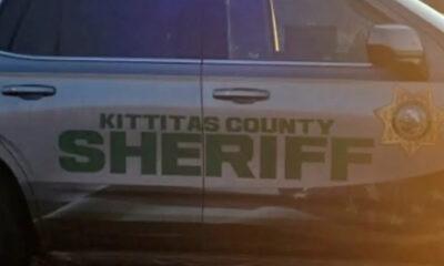 Side view of a Kittitas County Sheriff's patrol car with green SHERIFF lettering and a star badge on the door panel