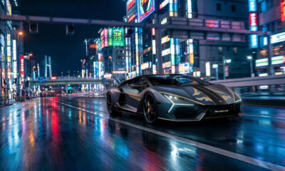 Silver sportscar with flame graphics cruising a neon-lit, rain-soaked city street at night, reflections on wet pavement.