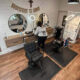 Cozy hair salon with two black barber chairs, round mirrors, and a 'Thank You' banner above the stations.
