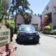 Sign reads Evann Court Condominium; a black SUV is parked in a driveway beside the red-stair apartment building and trees nearby.