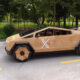 Wooden-paneled futuristic car sculpture parked on a street, with a white X on the door and wooden wheels.