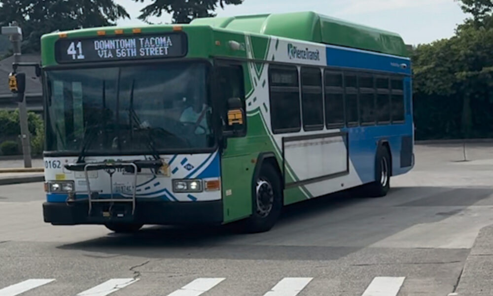 Public transit bus on a street, Route 41 to Downtown Tacoma via 56th Street, green and blue livery.
